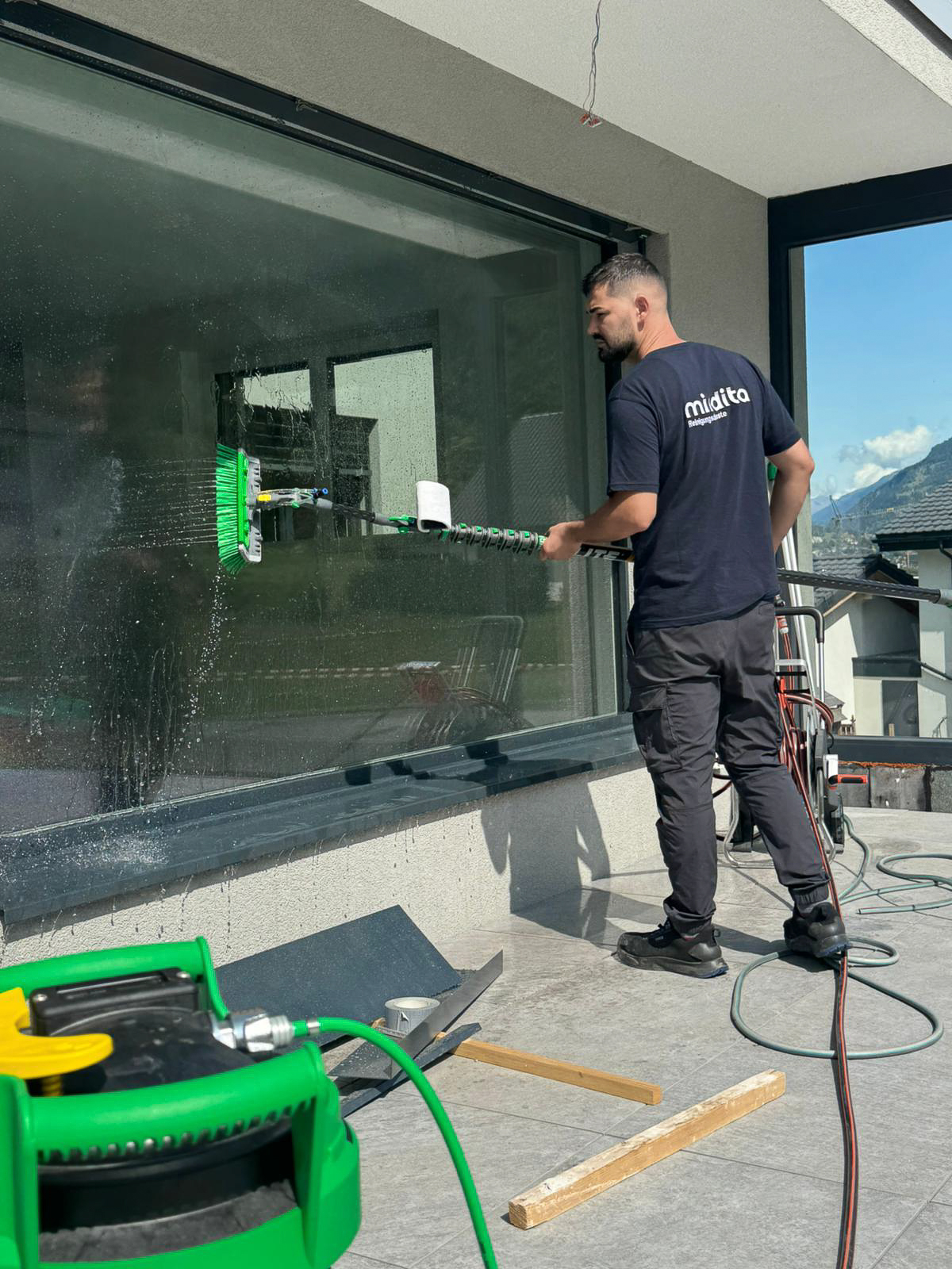 Fensterreinigung mit Blick auf die Walliser Berge